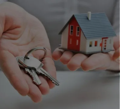 A person holding keys and a house model. Ideal for property management
