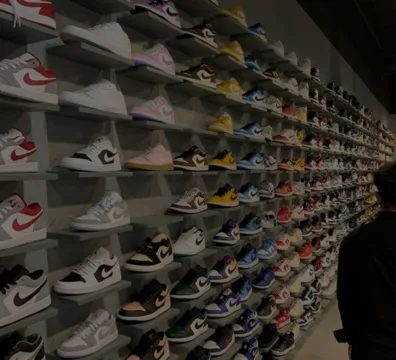 A man examining a wall of sneakers in a store