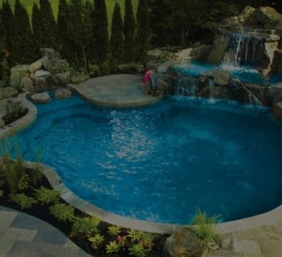 A sparkling blue swimming pool with people swimming and lounging by the water
