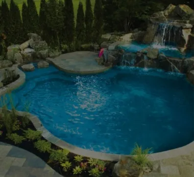 A sparkling blue swimming pool with people swimming and lounging by the water