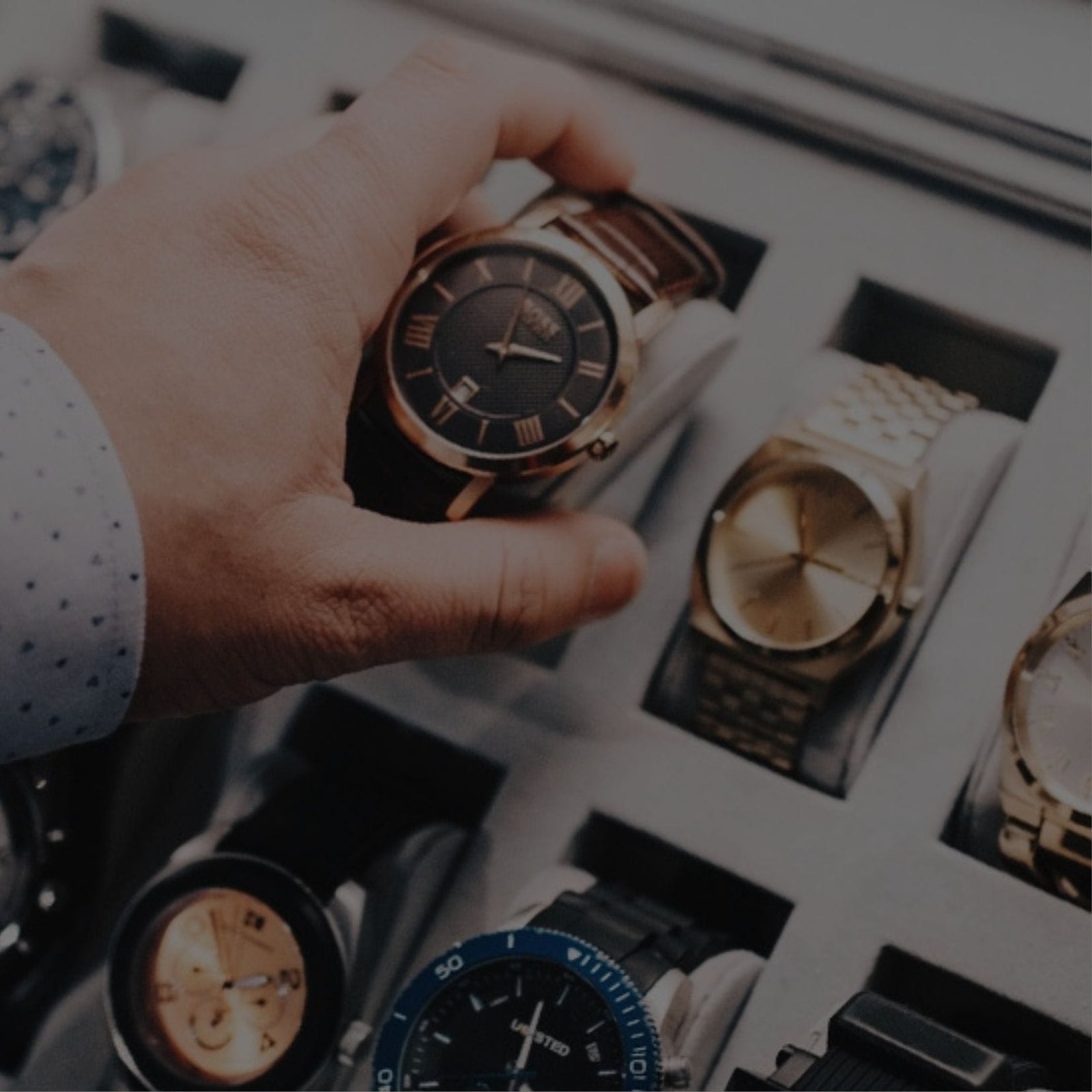 A person showcasing a watch in front of a variety of watches at a watch store