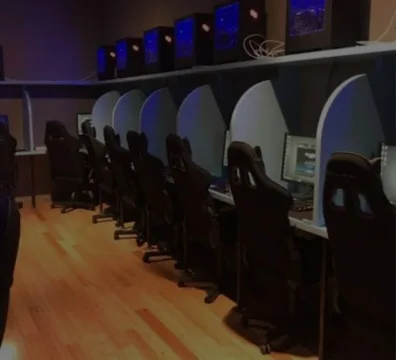 A room with computers and chairs for people to work and sit on