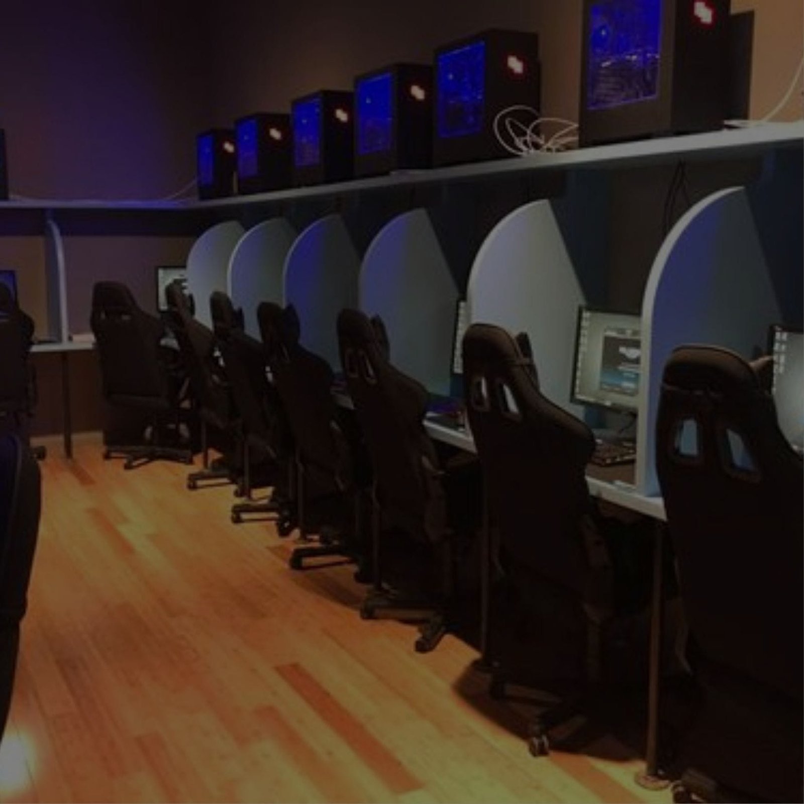 A room with computers and chairs for people to work and sit on