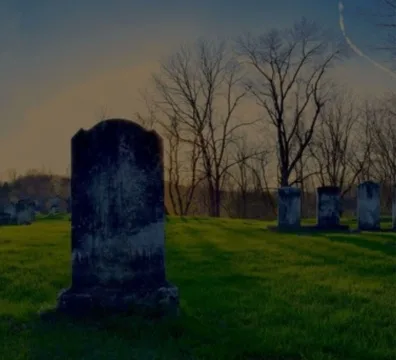 A cemetery with tombstones and trees in the background
