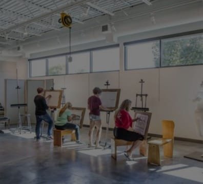 A diverse group of artists creating artwork in a vibrant art studio