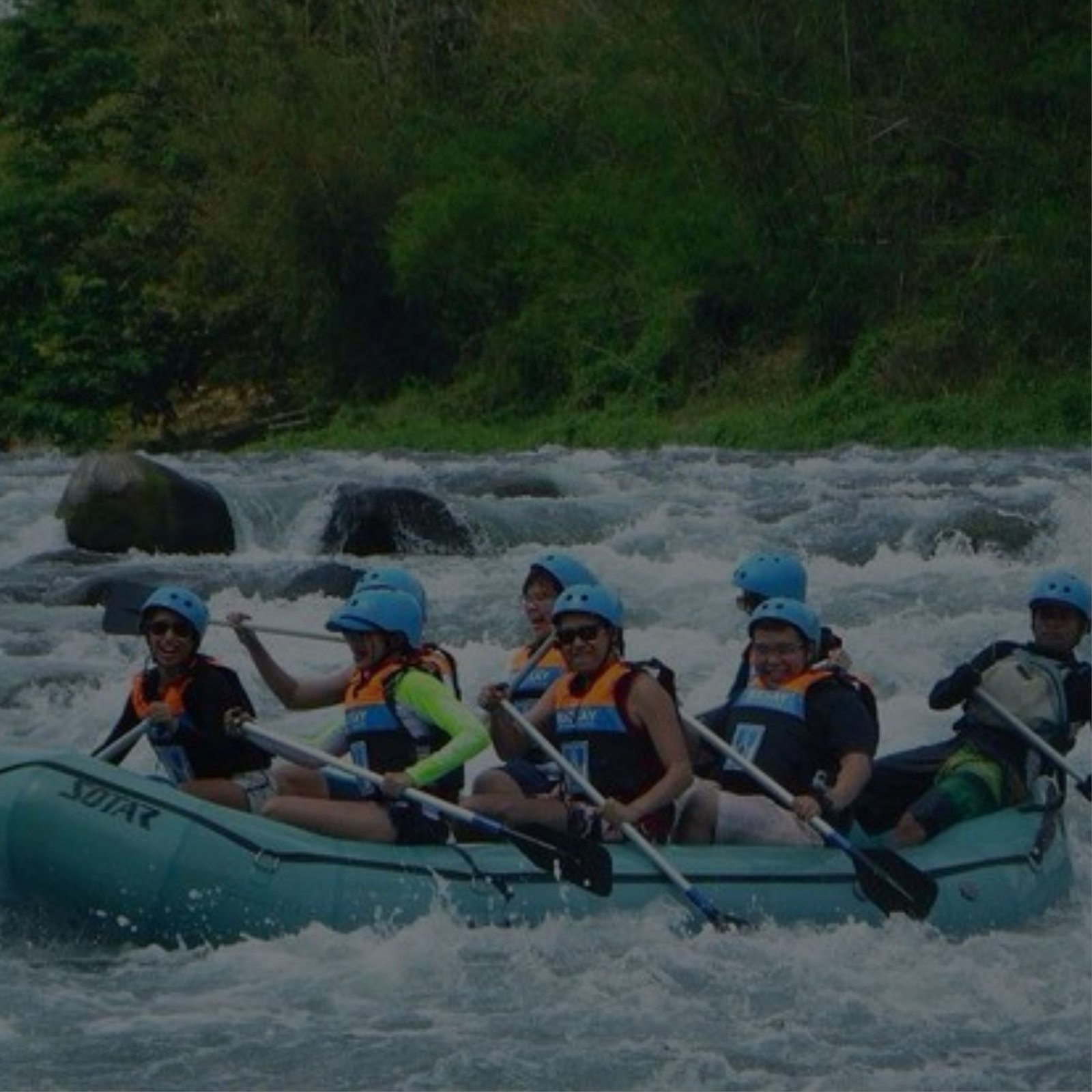 A group of people on a raft, floating down a river