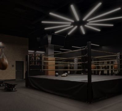 A well-lit boxing ring in a gym.