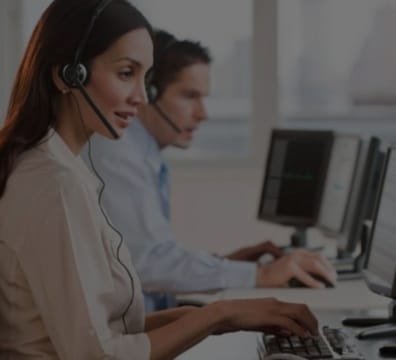 A woman and a man wearing headsets, working on a computer at a BPO company