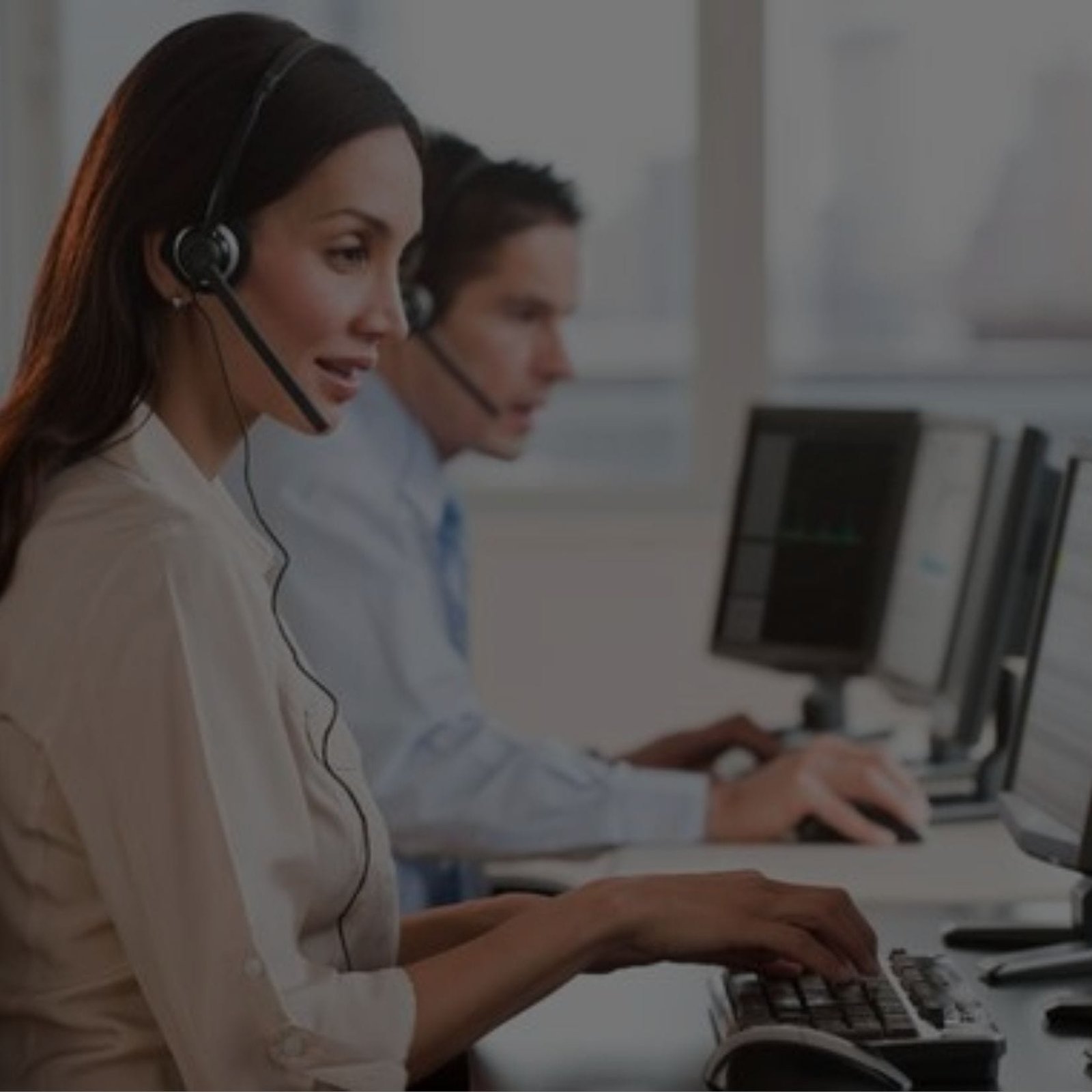 A woman and a man wearing headsets, working on a computer at a BPO company