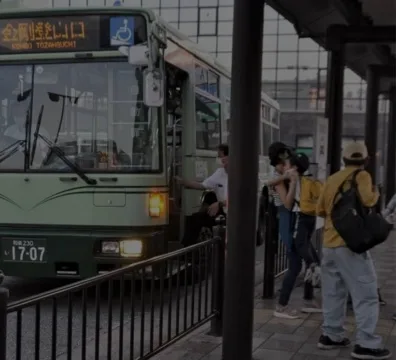 A green bus parked at a bus stop