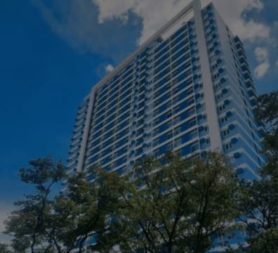 A tall building with trees and sky in the background at the center