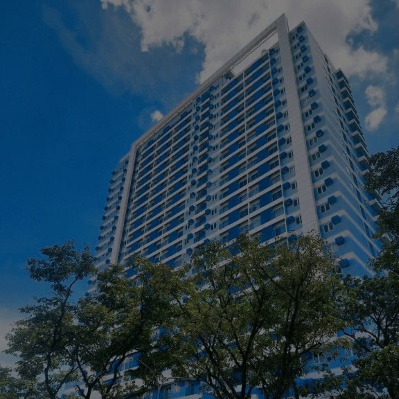 A tall building with trees and sky in the background at the center