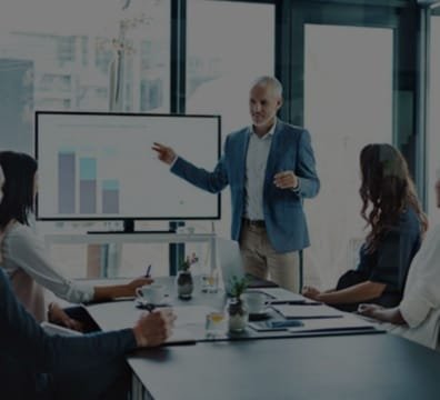 A presenter discussing business matters with a group of attentive listeners