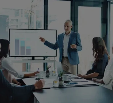 A presenter discussing business matters with a group of attentive listeners