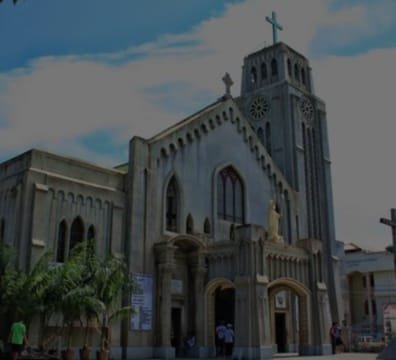 A church with a tall tower and a cross on top