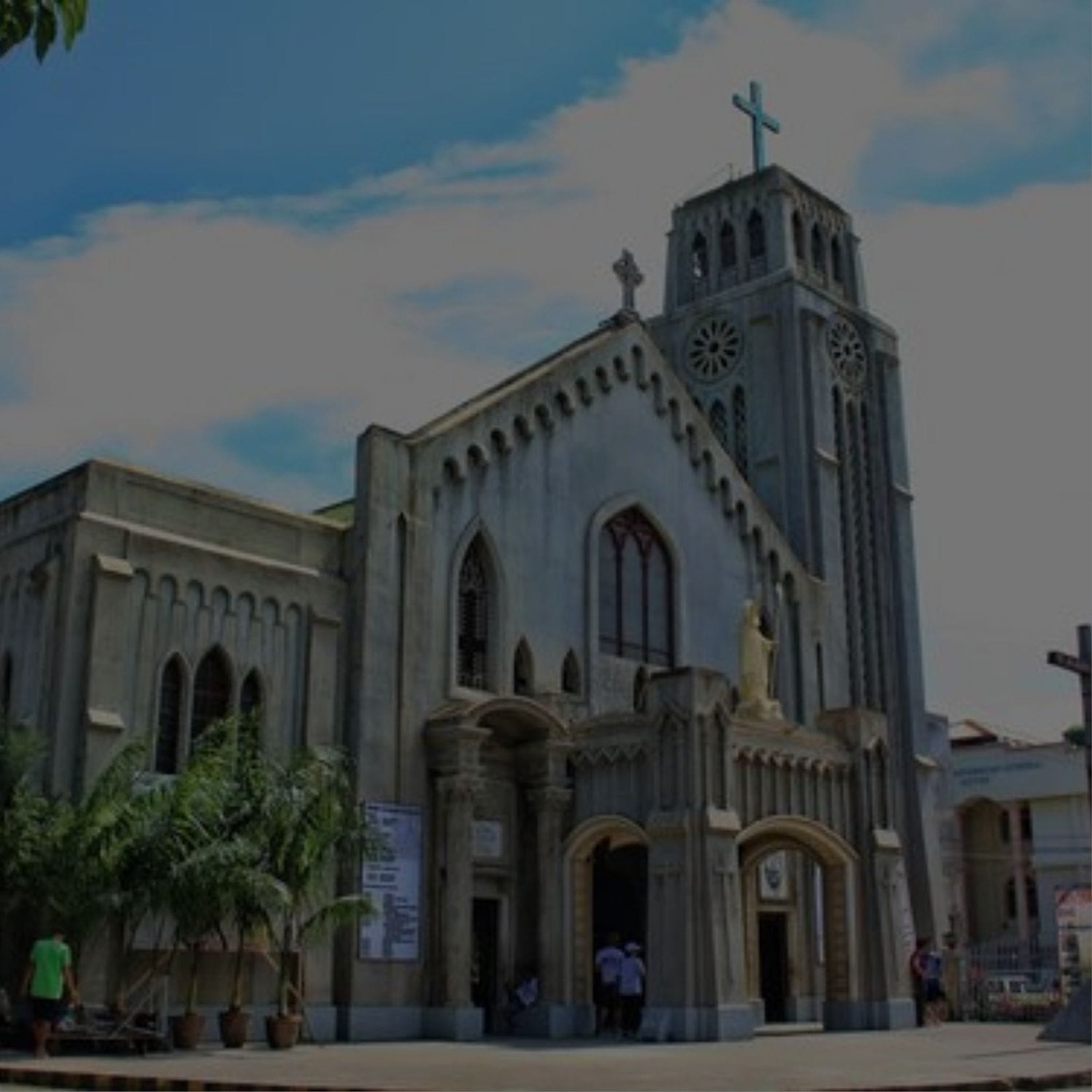 A church with a tall tower and a cross on top