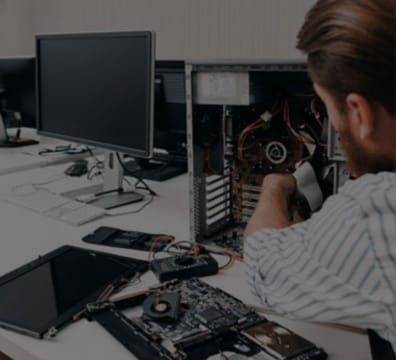 A man sitting at a desk, working on a computer