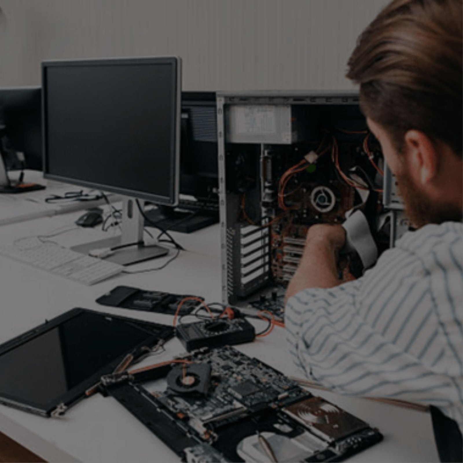 A man sitting at a desk, working on a computer