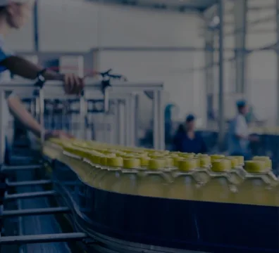 Food Manufacturer and Supplier a worker on a conveyor belt handling juice bottles