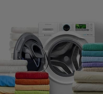 A washing machine with a stack of towels