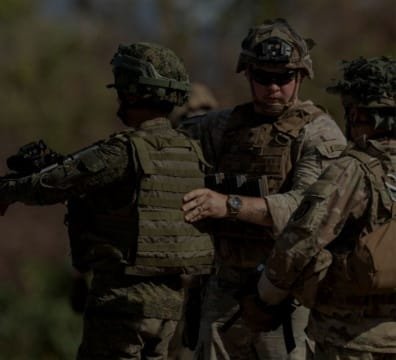 A group Military Base and Coast Guard standing together in a field, ready for action.
