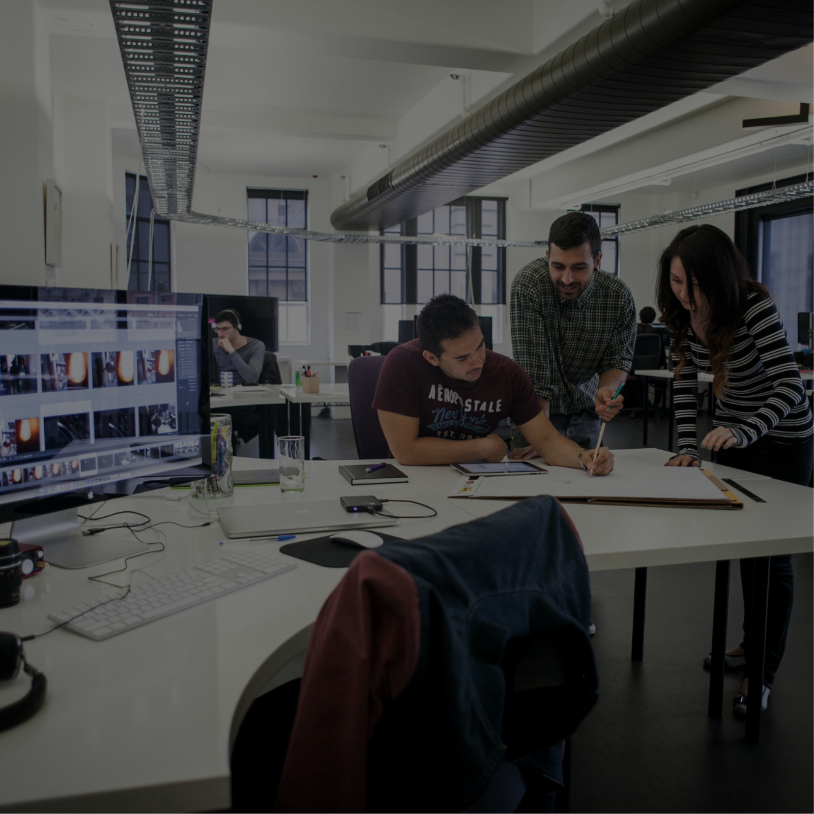 A team of professionals collaborating on a project in an office at an agency